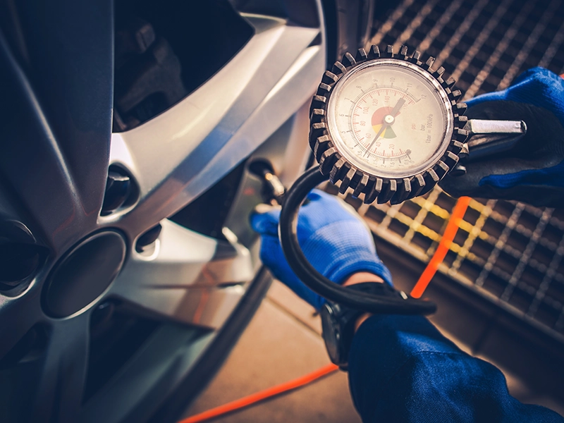 Mecánico midiendo la presión de las ruedas.